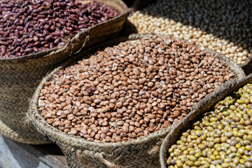 Assortment of multicolored beans in wicker baskets are sold at a local street food market on the island of Zanzibar, Tanzania, east Africa