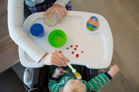 Overhead View Mother Feeding Baby Boy High Chair