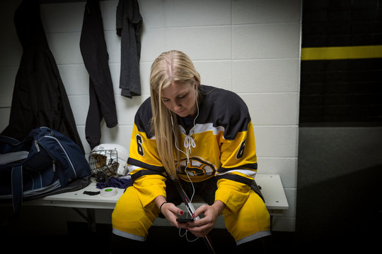 Female ice hockey player listening to mp3 player