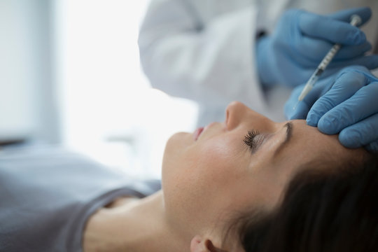 Woman Receiving Botox Injection In Forehead