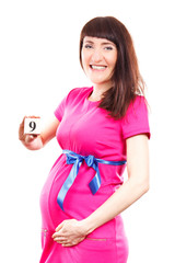 Pregnant woman showing number of ninth month of pregnancy, concept of expecting for newborn