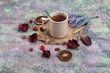 Red Hot Hibiscus tea in a glass mug on a wooden table among rose petals and dry tea custard with carcade