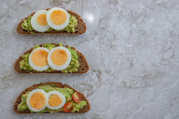 sliced avocado and egg on toasted bread for healthy breakfast or snack