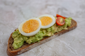 sliced avocado and egg on toasted bread for healthy breakfast or snack