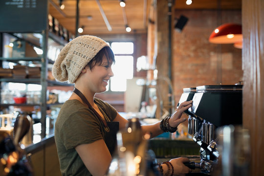 Barista using espresso machine in coffee shop