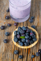 blueberry smoothie in a glass on wooden surface