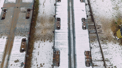 City Riga, Latvia.The locomotive pulls an empty cargo platform, visible rails and snow.