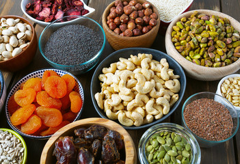 nuts, seeds and dried fruis on wooden surface