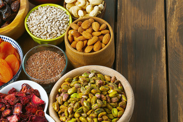 nuts, seeds and dried fruis on wooden surface