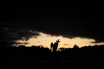 Ponte Sant'Angelo in Rome, Italy. Silhouette of angel statue at dramatic sunset