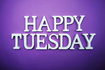 Happy Tuesday wooden letter alphabet on purple background