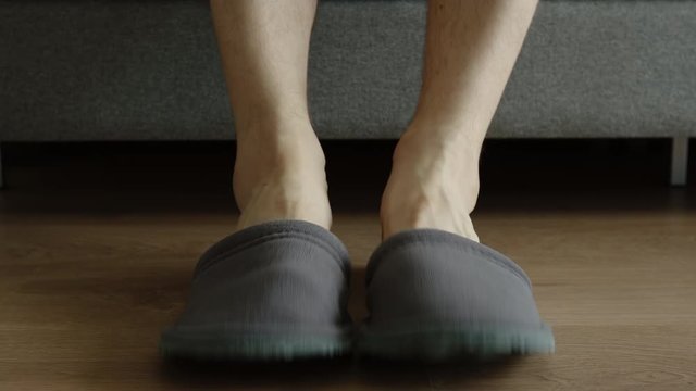 Young adult man slips a slippers and go out