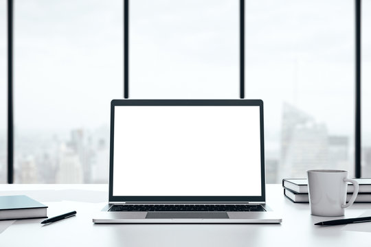 Laptop with blank white screen on a desktop on a big window background with city view, mockup. 3D Rendering