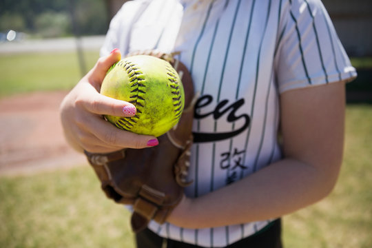 Close up middle school girl softball player holding fluorescent softball