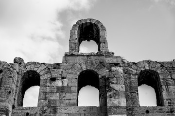 Black and white photo of Odeon of Herodes Atticus facade detail in Athens, Greece. Also known as Herodeion is a stone Roman theater located on Acropolis hill slope.