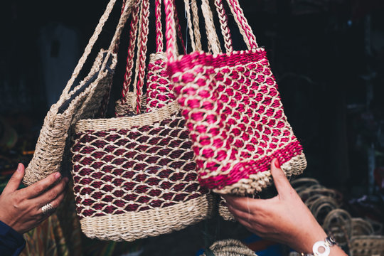 Womens' hands selecting handmade Abaca bags or purses, made from the fiber of Abaca plant and are quality products of the Philippines. Copy Space. Selective focus. Closeup.