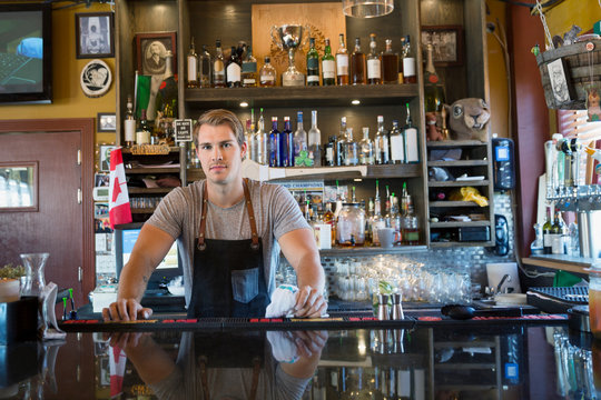 Portrait confident male bartender behind counter