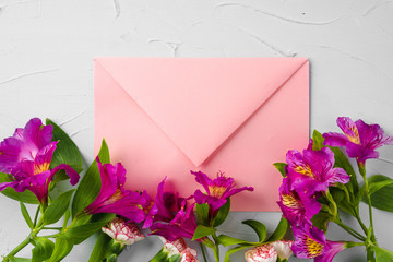 Pink envelope with flowers, top view. Romantic letter