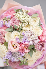 European floral shop. Beautiful bouquet of mixed flowers in womans hands. the work of the florist at a flower shop. Delivery fresh cut flower.