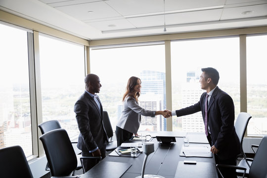 Business people handshaking in urban conference room meeting