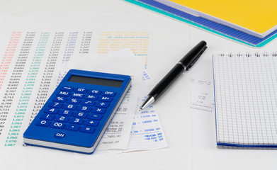 Calculator and notepad on top of supermarket receipt. Shopping and payment concept