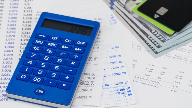 Payment card and calculator on top of supermarket receipt. Shopping and payment concept