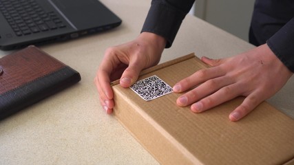 QR code technology. Small business. A Man pastes a Qr code on the package box. Delivery service....