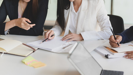 Cropped shot of two of businesswoman discussing on their project while sitting in co working space