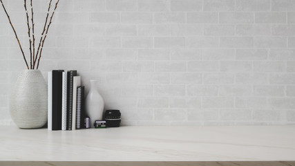 Close up view of workspace with copy space, ceramic vases and books on marble desk with white brick...