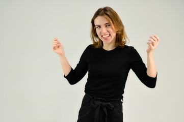 Studio portrait of a pretty blonde girl in a black T-shirt on a white background with bright emotions. A universal concept, the picture is suitable for any topic.