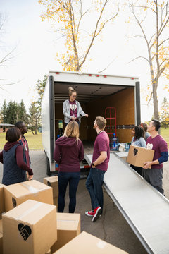 Volunteers unloading cardboard boxes from truck