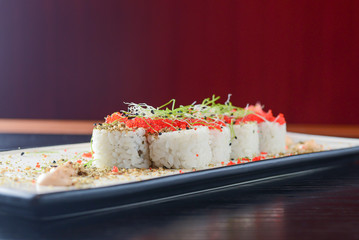 Maki Sushi California rolls with fresh salmon, cucumber and cream cheese philadelphia inside with red caviar and herbs