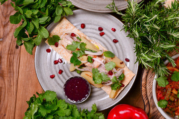 Georgian cuisine - rack of lamb with lavash bread, satsebeli sauce and greens served on a plate.