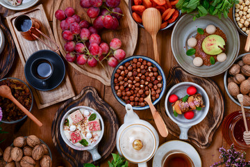 Traditional Turkish coffee, walnuts, grapes, different desserts, tea with a tea pot, white chocolate pear on table.