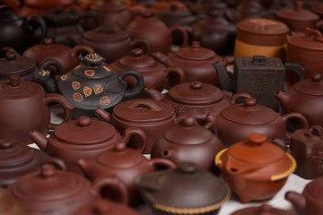 Clay Chinese teapots, a variety of species on the counter of the car shop. Different brown colors. Kettle turtle