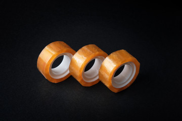 Set of rolled adhesive tape at black background