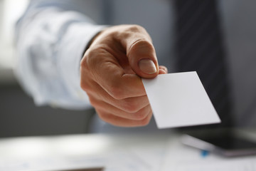 Male arm in suit give blank calling card to visitor closeup. White collar colleagues company name exchange job interview sale clerk id executive or ceo finance support formal identity concept