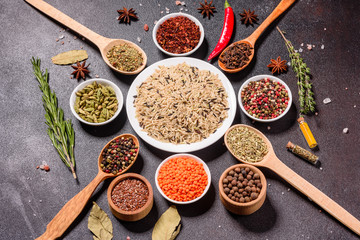 A set of spices and herbs. Indian cuisine. Pepper, salt, paprika, basil and other on a dark background