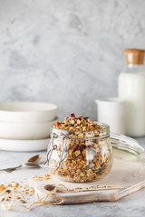 Organic homemade granola cereal with oats, nuts and dried berries. Muesli in a glass jar. Healthy...