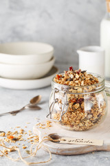 Organic homemade granola cereal with oats, nuts and dried berries. Muesli in a glass jar. Healthy vegan breakfast or snack. Copy space for text. Proper nutrition concept