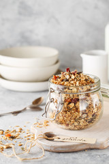 Organic homemade granola cereal with oats, nuts and dried berries. Muesli in a glass jar. Healthy vegan breakfast or snack. Copy space for text. Proper nutrition concept