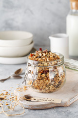 Organic homemade granola cereal with oats, nuts and dried berries. Muesli in a glass jar. Healthy vegan breakfast or snack. Copy space for text. Proper nutrition concept