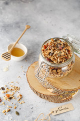 Organic homemade granola cereal with oats, nuts and dried berries. Muesli in a glass jar. Healthy vegan breakfast or snack. Copy space for text. Proper nutrition concept