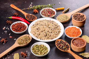 A set of spices and herbs. Indian cuisine. Pepper, salt, paprika, basil and other on a dark background