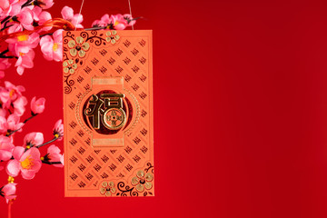 Chinese New Year Decoration. Red Packet on Plum Branch,Character on Packet Symbolizes Good Luck.