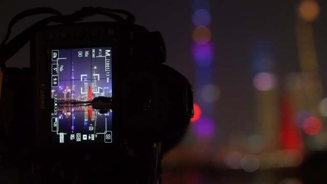 Camera Closeup with Beautifully Lit Shanghai Skyline on screen at Night 4k