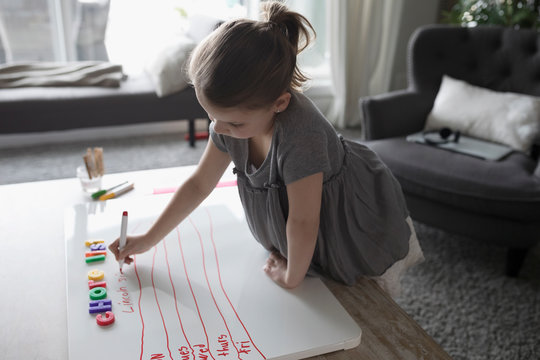 Girl Making Chore List On Whiteboard