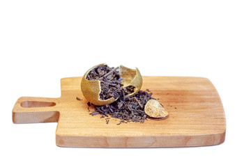 Chinese sheng puer tea in a broken dried tangerine closeup on a cutting board on a white background. Selective focus.