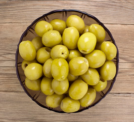  Green olives  in bowl on wooden table