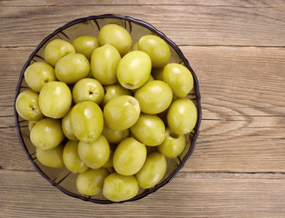  Green olives  in bowl on wooden table